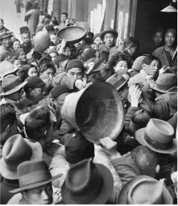 _**A crowd of citizens push towards a government station selling rice very cheaply**_